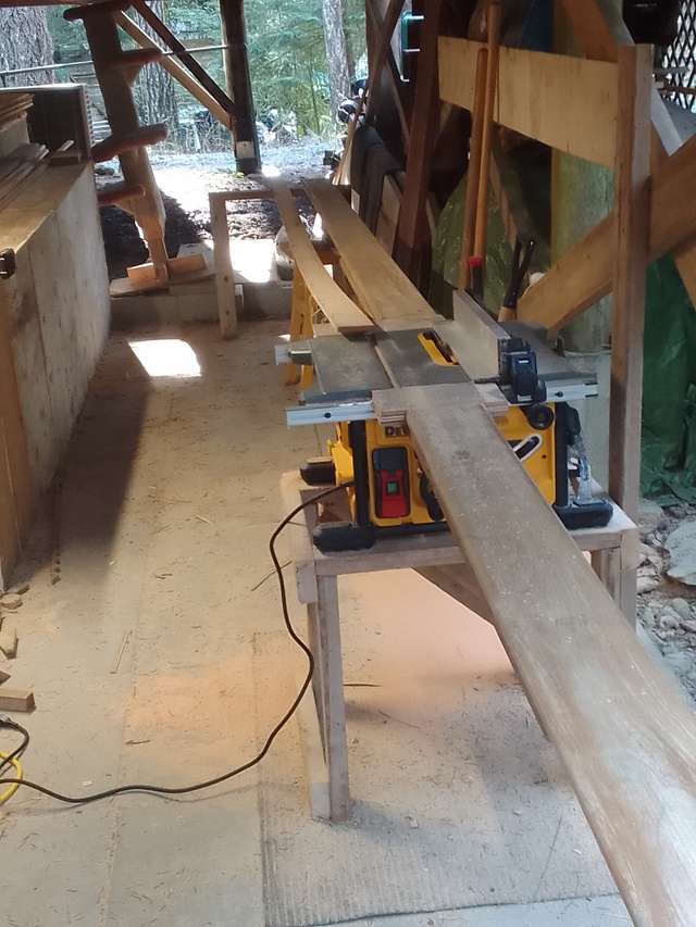 Long deckboards running to table saw to support fir slabs for ripping.