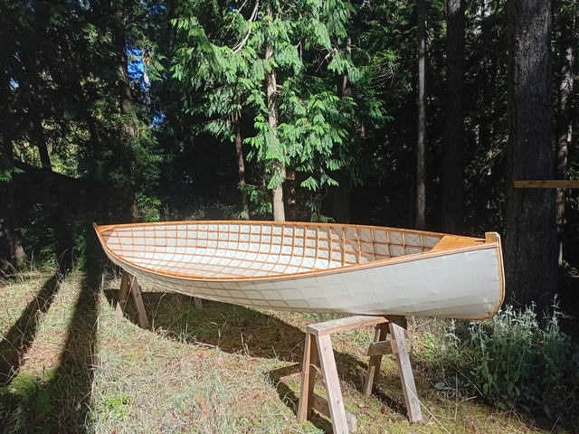 Picture of the skinned boat upright on sawhorses in the sun